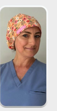 Healthcare worker in scrubs wearing a floral surgical cap.